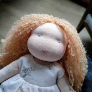 La poupée Waldorf Capucine de Pique & Colegram a les cheveux bouclés