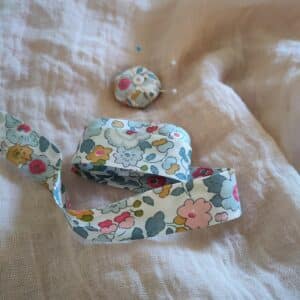 Le biais Liberty Betsy porcelaine apporte une touche de délicatesse sur les vêtements des poupées.